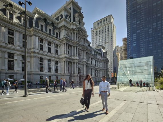 Two individuals walking in the plaza in front of Philadelphia's City hall 